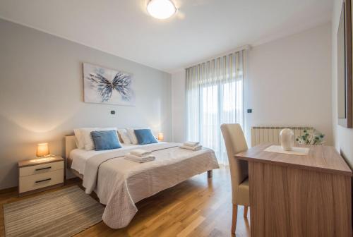 Un dormitorio con una cama con almohadas azules y un escritorio. en Villa Ritoša, a beautiful pool villa surrounded by greenery, en Trviž