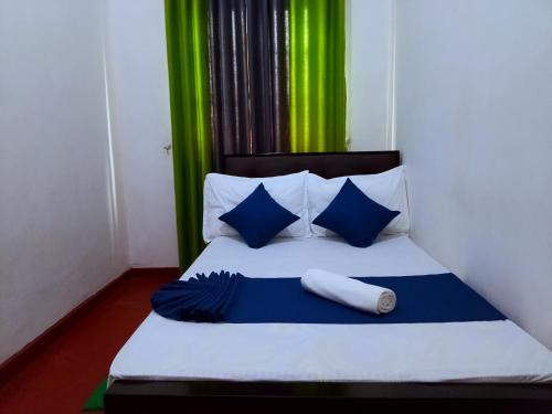 a bedroom with a bed with blue and green curtains at Green Villa in Nuwara Eliya