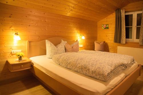 ein Schlafzimmer mit einem Bett in einer Holzhütte in der Unterkunft Alpenrösle in Balderschwang