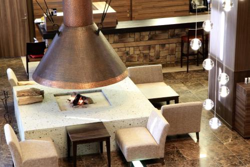 a large bell hanging over a table with chairs at Karuizawakurabu Hotel 1130 Hewitt Resort in Tsumagoi