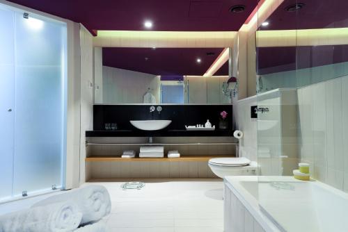 a bathroom with a sink and a toilet and a tub at NYX Tel Aviv in Tel Aviv