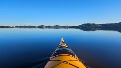 a view from the inside of a kayak on a lake at Family-friendly Cabin with pier - Herdla to Bergen - 40 min in Herlø
