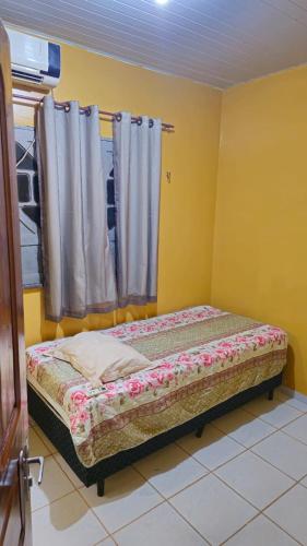 a small bed in a room with a window at Casa 3 quartos em Juruti in Juruti