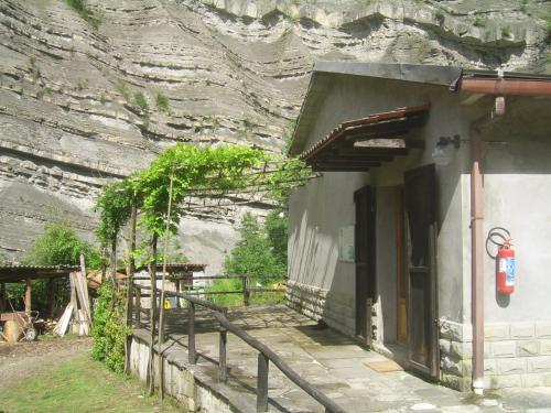 a building with a fence next to a stone wall at Agriturismo Mulino di Culmolle in Raggio