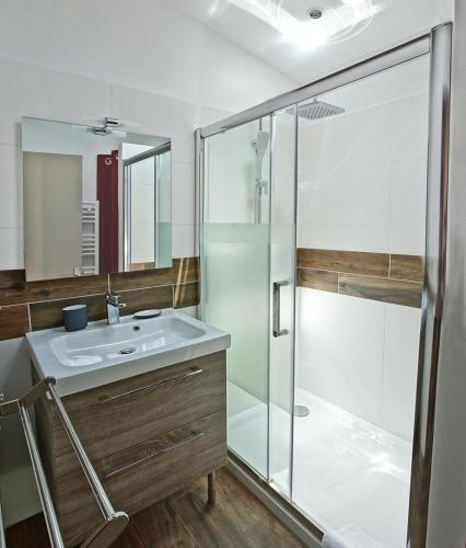 une salle de bain avec un lavabo et une douche dans l'établissement Les Secrets de Sainte Eulalie - Première Conciergerie, à Montpellier