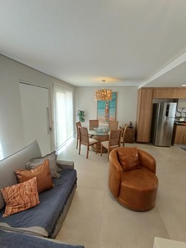 a living room with a couch and a table at Casa com 3 suítes em condomínio com piscina em Juquehy in São Sebastião