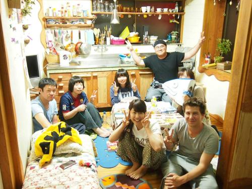 a group of people sitting in a room at Katsuo Guest House in Kochi