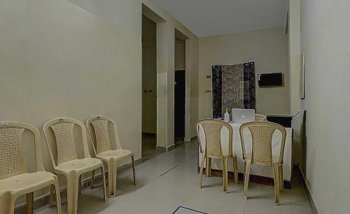 a dining room with chairs and a table and a television at Super Collection O Velachery Railway Junction Formerly Vijay Guest House in Chennai