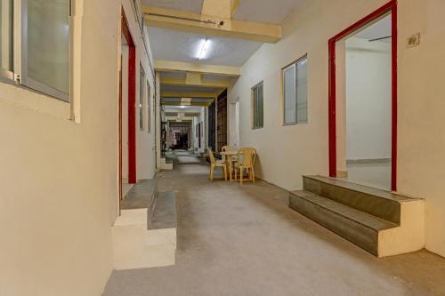 an empty hallway with stairs and a table and chairs at Super Collection O Velachery Railway Junction Formerly Vijay Guest House in Chennai