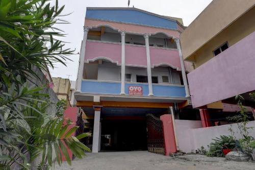 a pink and blue building with a sign on it at Super Collection O Velachery Railway Junction Formerly Vijay Guest House in Chennai