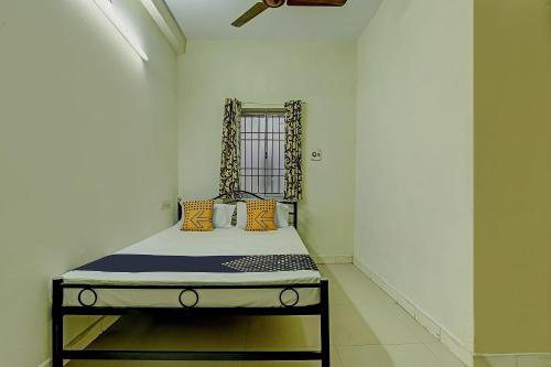 a small bed in a room with at Super Collection O Velachery Railway Junction Formerly Vijay Guest House in Chennai