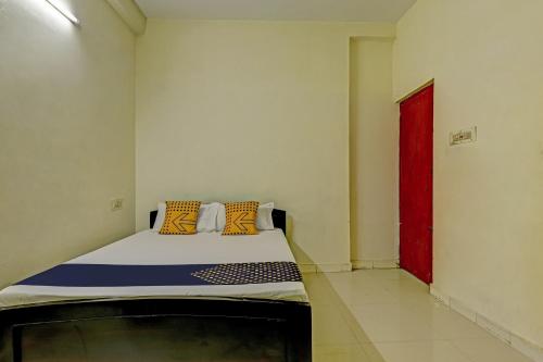 a bed in a room with a red door at Super Collection O Velachery Railway Junction Formerly Vijay Guest House in Chennai