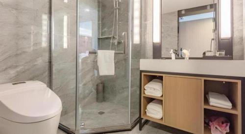 a bathroom with a shower and a toilet and a sink at Yanji Yanbian International Hotel in Yanji