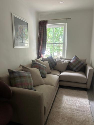 a living room with a couch and a window at Corbridge Apartment in Corbridge