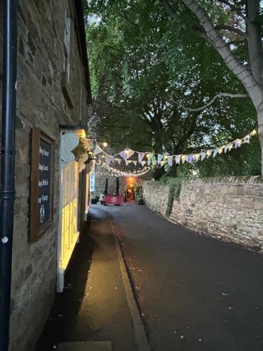 an alley with a string of lights on a wall at Corbridge Apartment in Corbridge