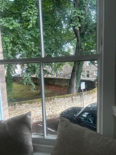 a window with a view of a car parked outside at Corbridge Apartment in Corbridge