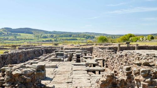 ancient ruins of a building with mountains in the background at Corbridge Apartment in Corbridge