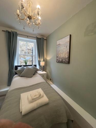a bedroom with a bed and a chandelier at Corbridge Apartment in Corbridge