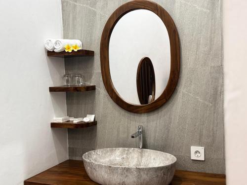 a bathroom with a large sink and a mirror at Dé Kamala Bali in Nusa Dua