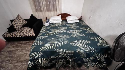 ein Schlafzimmer mit einem Bett mit einer schwarz-weißen Bettdecke in der Unterkunft Ocean Whisper Guest House in Mirissa