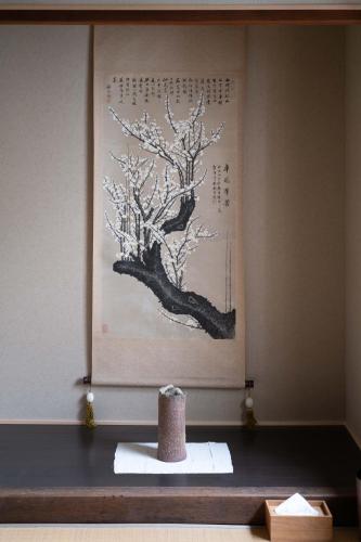 a table with a picture of a tree on the wall at Soyogi Stay in Takayama