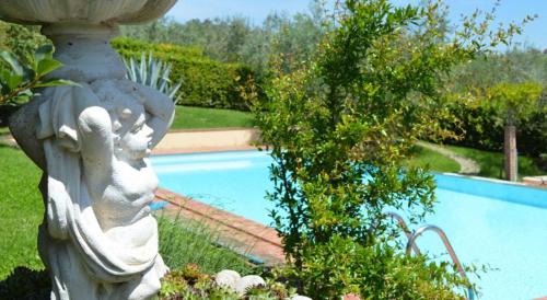 a statue next to a swimming pool in a yard at Podere Villabassa in Montespertoli