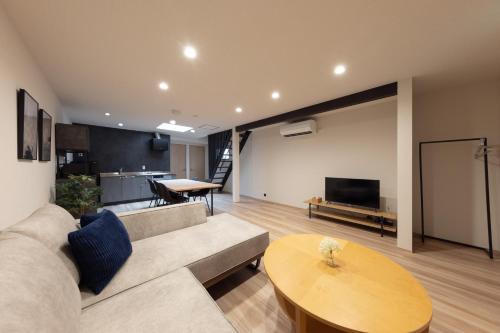 a living room with a couch and a table at Soyogi Stay in Takayama
