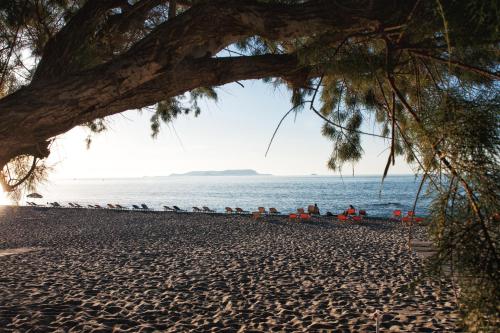 a beach with people sitting on the sand at Axos Apartments in Hersonissos