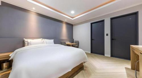 a bedroom with a large white bed and sliding doors at Hotel Primo Daejeon in Daejeon