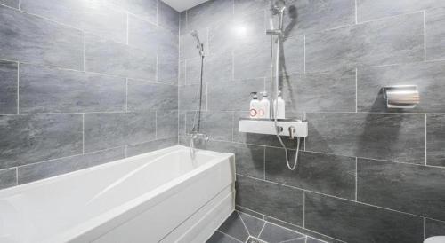 a bathroom with a bath tub and a sink at Hotel Primo Daejeon in Daejeon