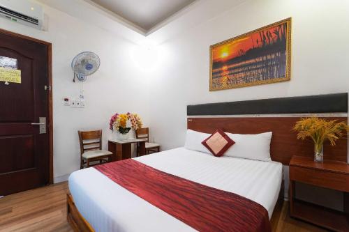 a bedroom with a bed and a desk with a chair at Belvilla in District 8 Near Ben Thanh Market Formerly Eva Hotel in Ho Chi Minh City