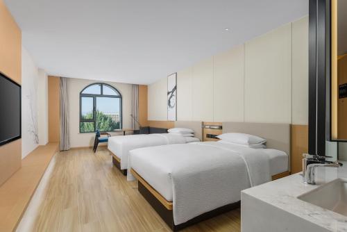a hospital room with four beds and a sink at Fairfield by Marriott Yining in Yining
