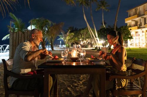 a man and a woman sitting at a table on the beach at Insight Resort Ahangama - S&S Other Certified in Ahangama