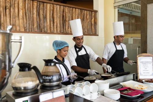 three chefs standing in a kitchen preparing food at Insight Resort Ahangama - S&S Other Certified in Ahangama