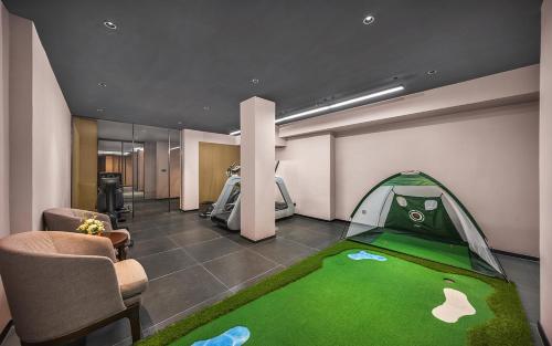 a room with a golf course with a bed in the background at 威海市区威高广场万信至格酒店 in Weihai