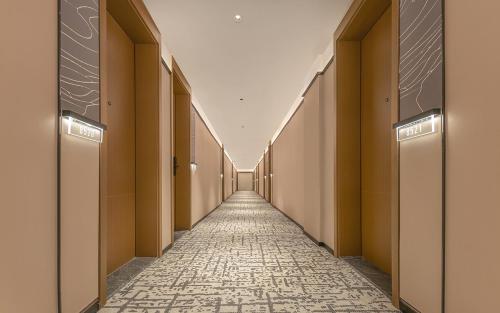 a corridor of an empty building with a tile hallway at 威海市区威高广场万信至格酒店 in Weihai