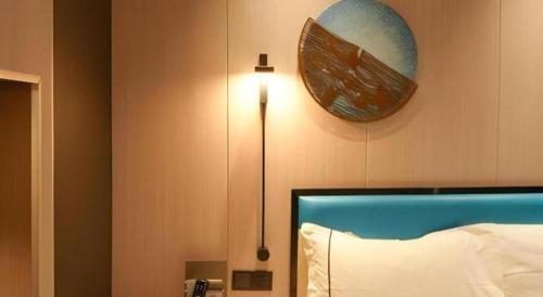 a bedroom with a bed and a clock on the wall at Golden Central Hotel Shenzhen in Shenzhen