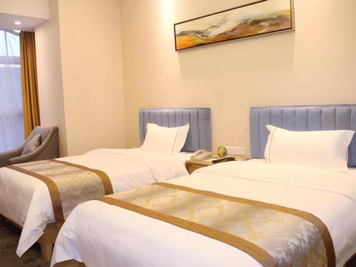 two beds in a hotel room with white sheets at Golden Central Hotel Shenzhen in Shenzhen