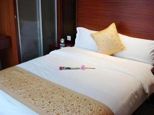 a white bed with a toy on top of it at Golden Central Hotel Shenzhen in Shenzhen