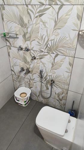 a bathroom with a toilet and a wall at Ashirvad Homes in Mannārakkāt