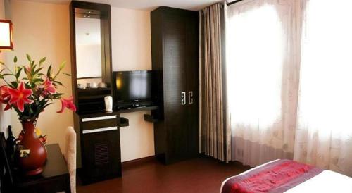 a hotel room with a bed and a television at New Moon Hotel in Hanoi