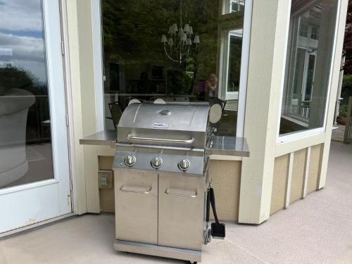 a grill sitting outside of a building next to a window at Luxury 5BR Villa, Gym, Theater & Ocean Views in West Vancouver