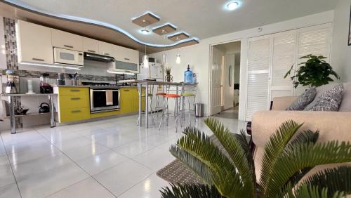 a kitchen and living room with a couch and a table at Departamento céntrico, amplio y nuevo cerca del Aeropuerto y GNP-Foro sol in Mexico City