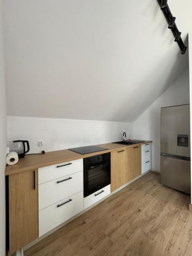 a kitchen with white cabinets and a stove top oven at Domki wypoczynkowe LAS in Śliwice