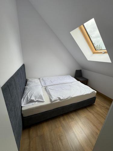 a bedroom with a bed in a white room at Domki wypoczynkowe LAS in Śliwice