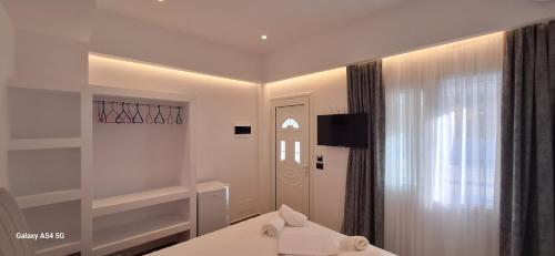 a white room with a bed and a window at Cozy White House - Near Beach Private Jacuzzi in Ksamil
