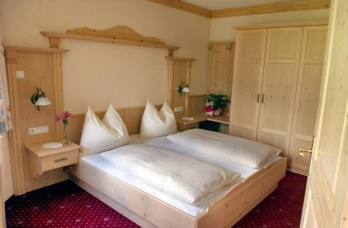 a bedroom with a bed with white pillows at Sagritzerwirt in Großkirchheim