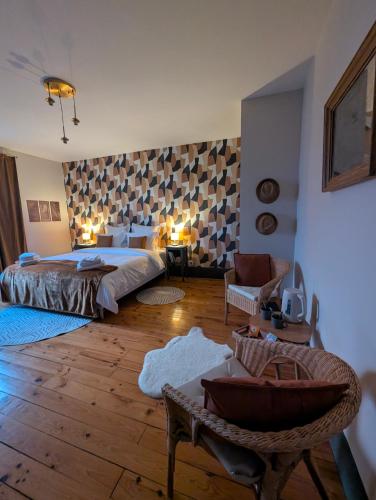 a bedroom with a king sized bed and a chair at La Maison d'Arlette - Maison d'Hôte et Gite au coeur de l'Isère à 10 mn de Voiron, capitale de la Chartreuse, et du Lac de Paladru in Saint-Blaise-du-Buis