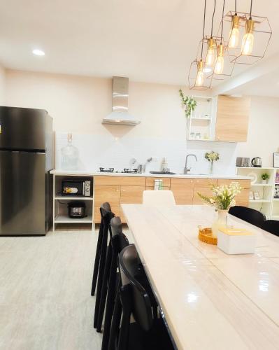 a kitchen with a large table and a refrigerator at Kiddie Hostel 13A1-Kids and pets friendly in Kababae