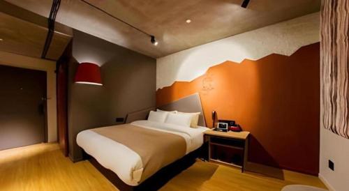 a bedroom with a bed and a red wall at YUNIK-Shanghai Zhongshan Park Yan'an Xi Road in Shanghai
